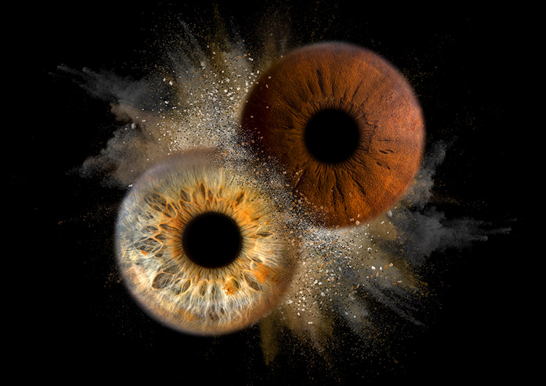 Makro fotografija dveh očes s kreativnim efektom eksplozije na črnem ozadju