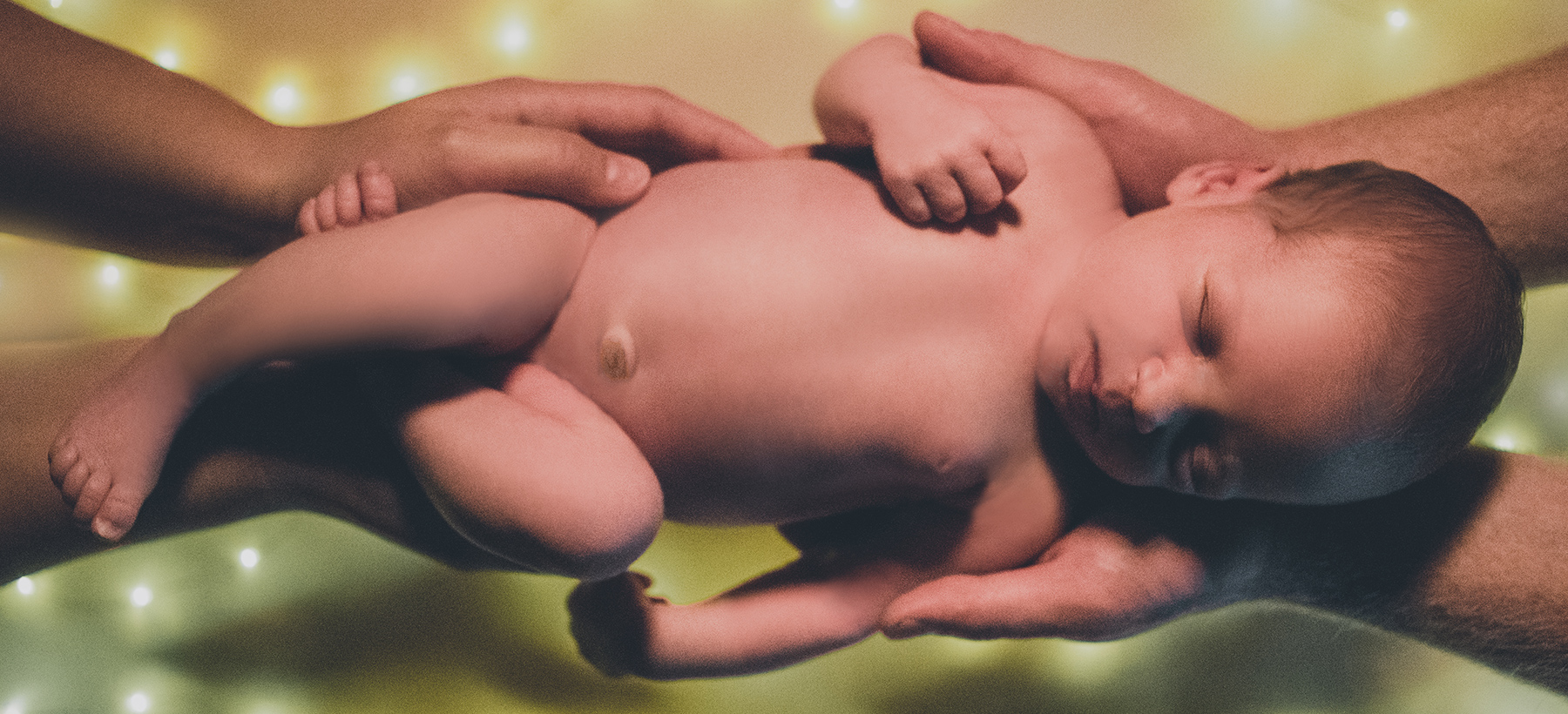 Fotografiranje novorojenčka v dlaneh staršev.